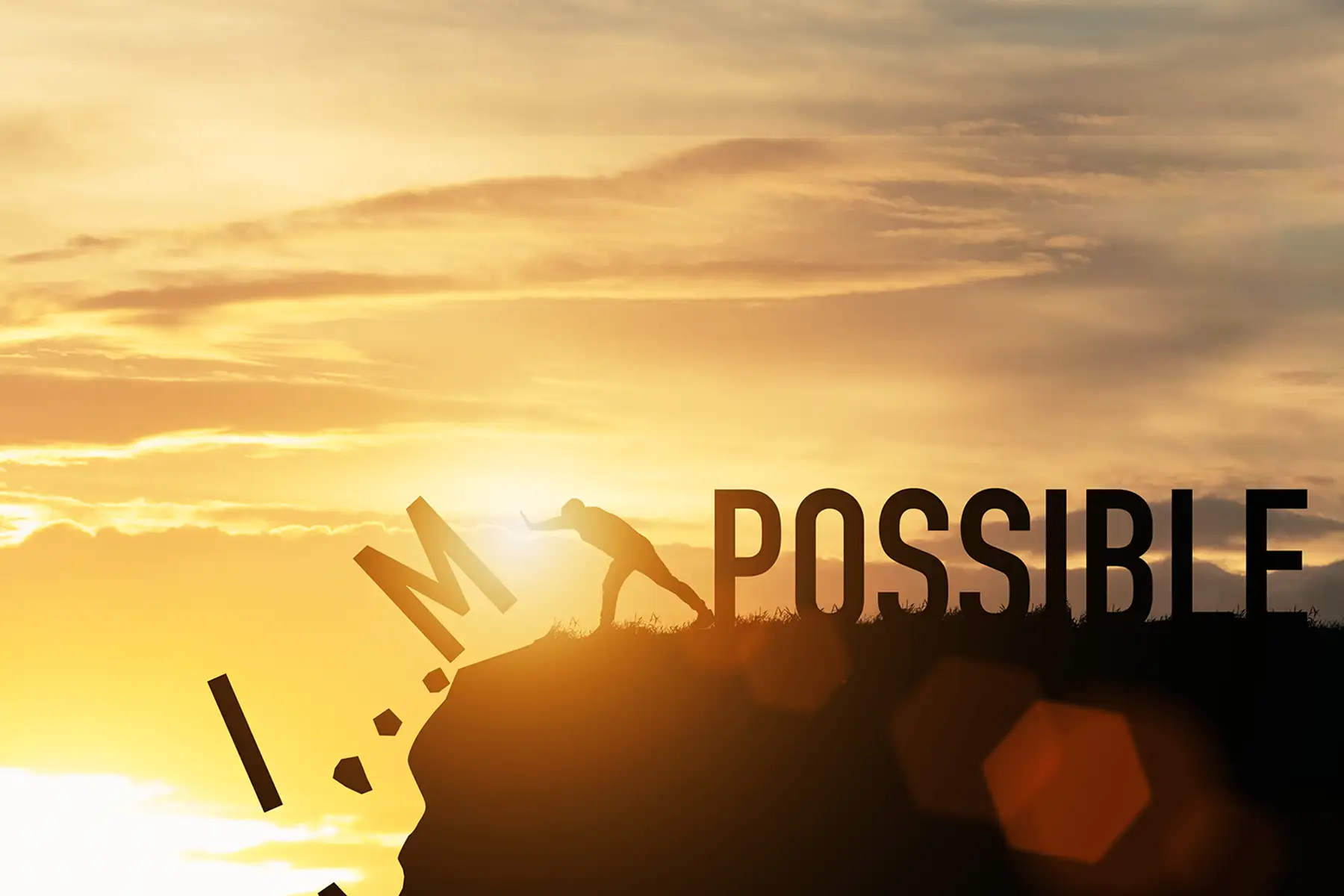 A man pushing the letters I and M off the edge of a cliff to leave the word Possible behind