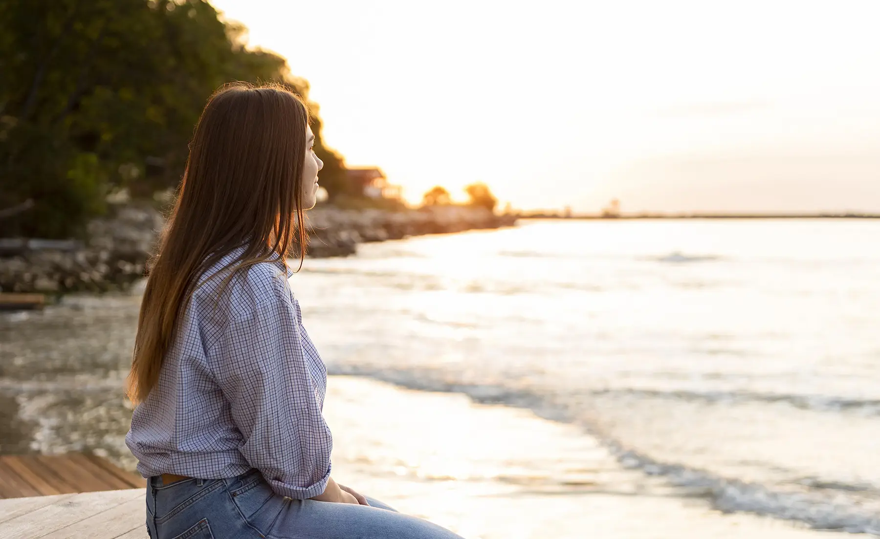 Young woman looking at the ocean at sunrise